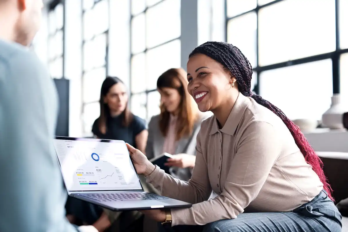 A photo of a professional showing data management results on a laptop